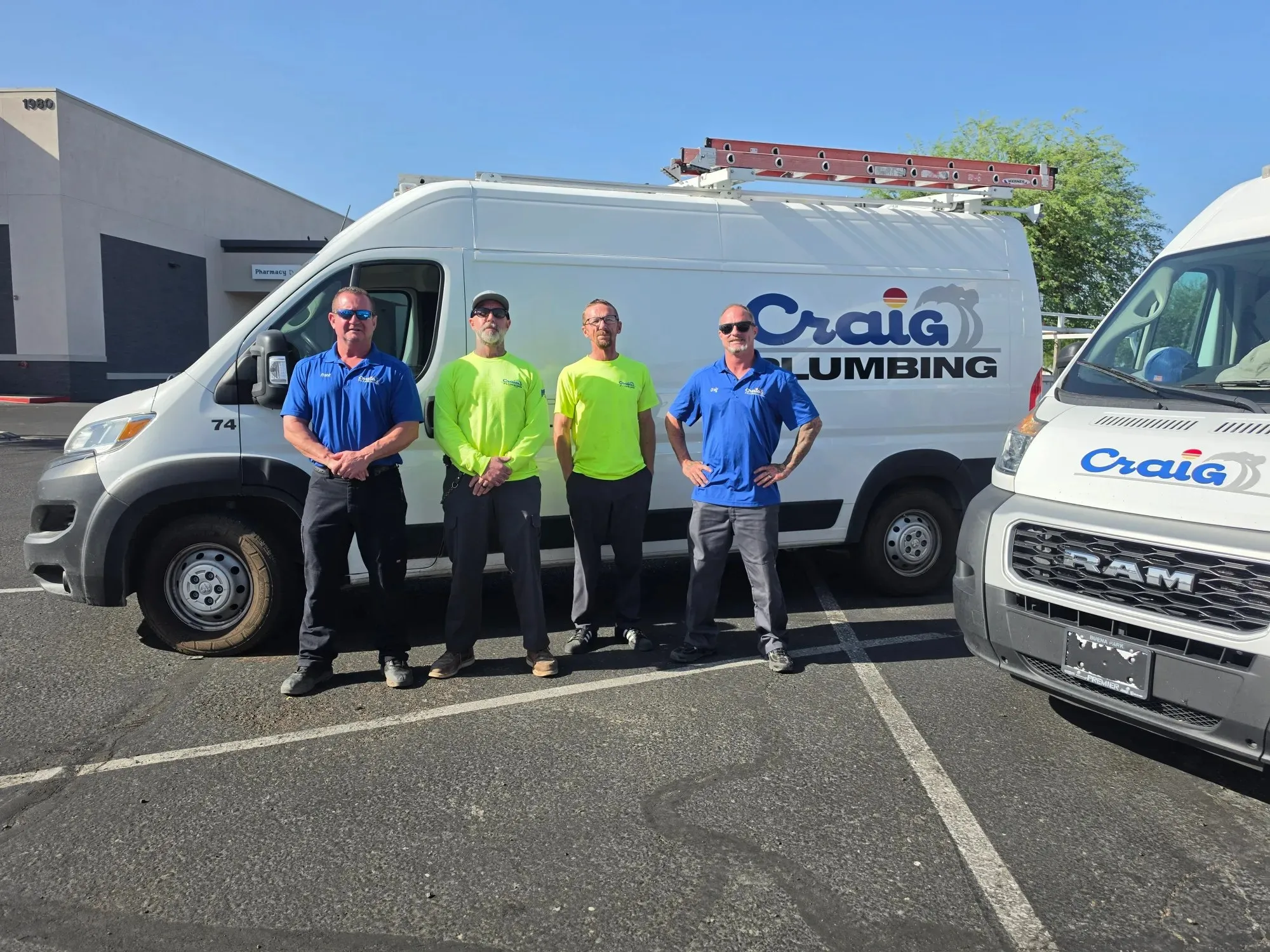Four Craig Plumbing plumbers standing in front of a Craig Plumbing service van